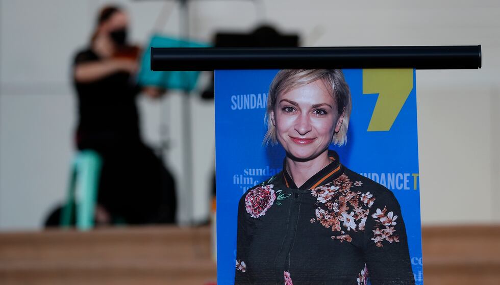 A musician plays a violin behind a photograph of cinematographer Halyna Hutchins during a...