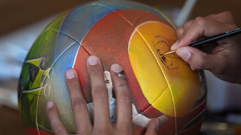 Artist Lili Cantero paints a soccer ball with images commemorating Spain's 2010 World Cup...