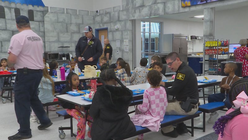 First responders and elementary schoolers are having lunch together.