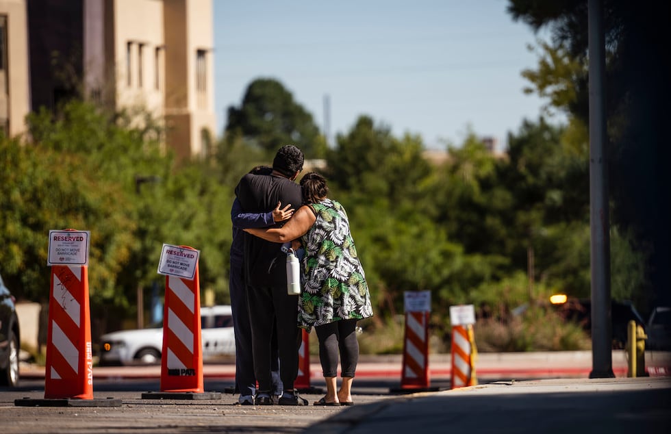 Family members embrace at the University of New Mexico Central Campus after a deadly shooting...