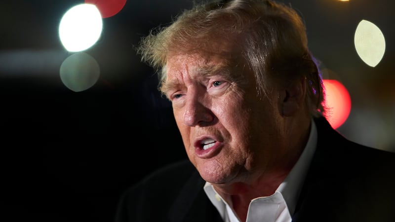 President Donald Trump speaks with reporters as he arrives on Air Force One, Wednesday, Oct....