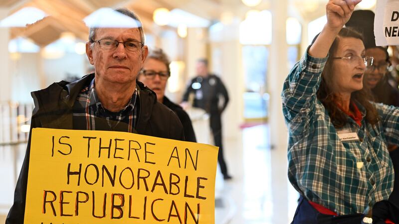 A protester holds a sign as the Republican-dominated North Carolina House convened to complete...