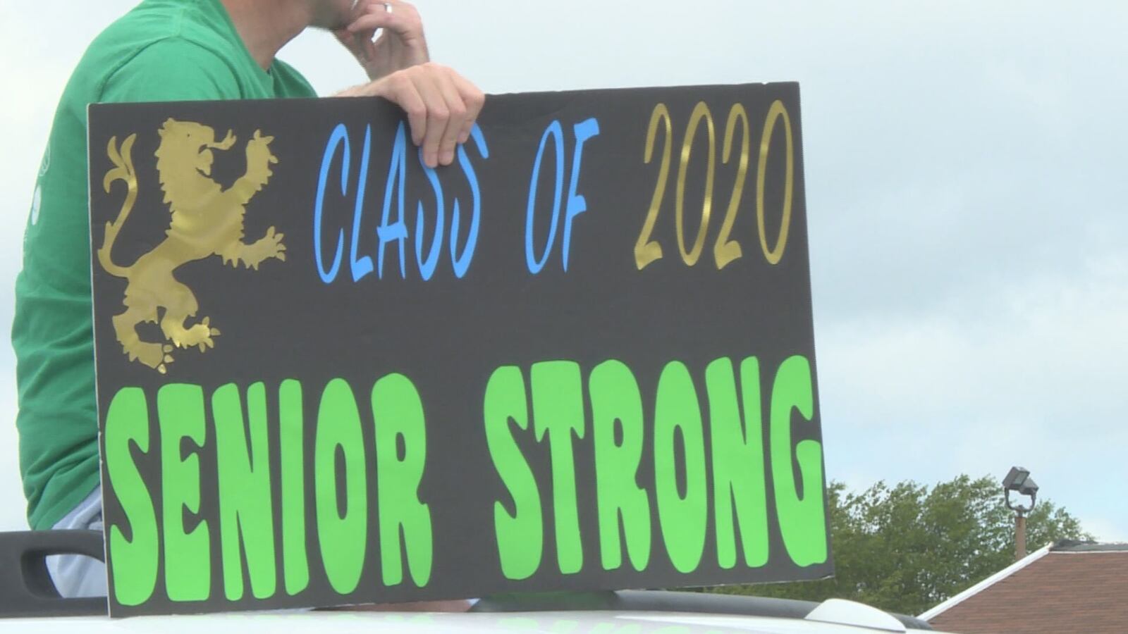 School staff cheer on J.H. Rose seniors picking up caps and gowns