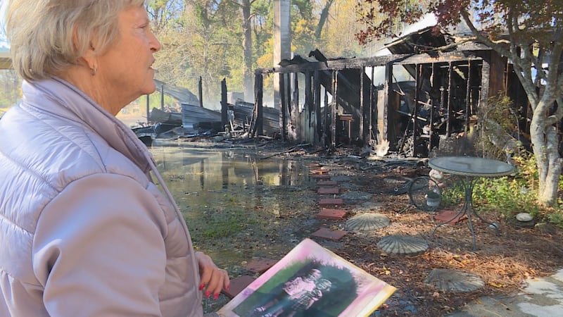 Brenda Parsons, with the help of firefighters on scene, salvages family pictures after her...